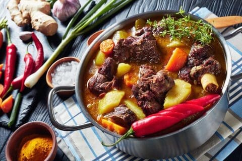 Hearty beef stew with vegetables in a rustic pot.